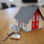 Home Buying - white and red wooden house miniature on brown table