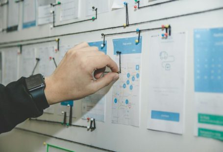 Business Plan - person working on blue and white paper on board