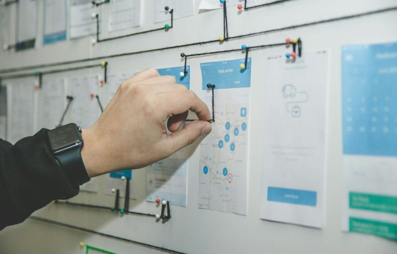 Business Plan - person working on blue and white paper on board